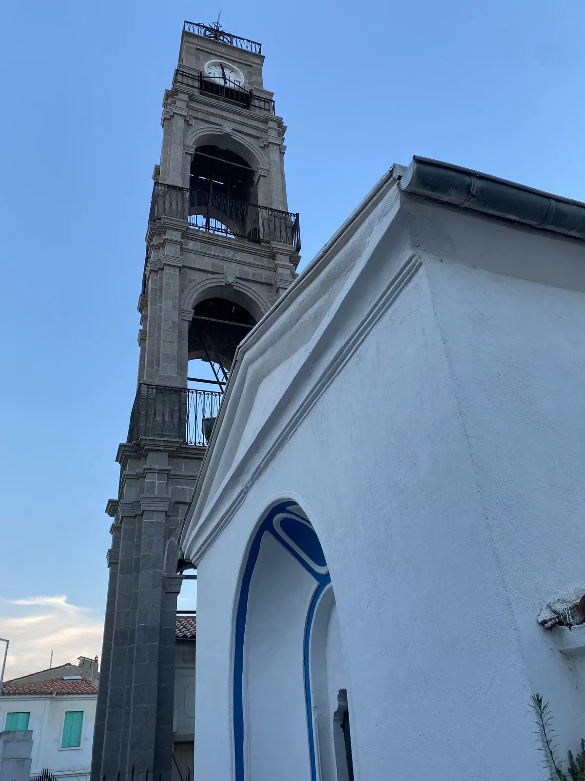 Το πέτρινο καμπαναριό δίπλα στον ασβεστωμένο ναό της Κοιμήσεως της Θεοτόκου