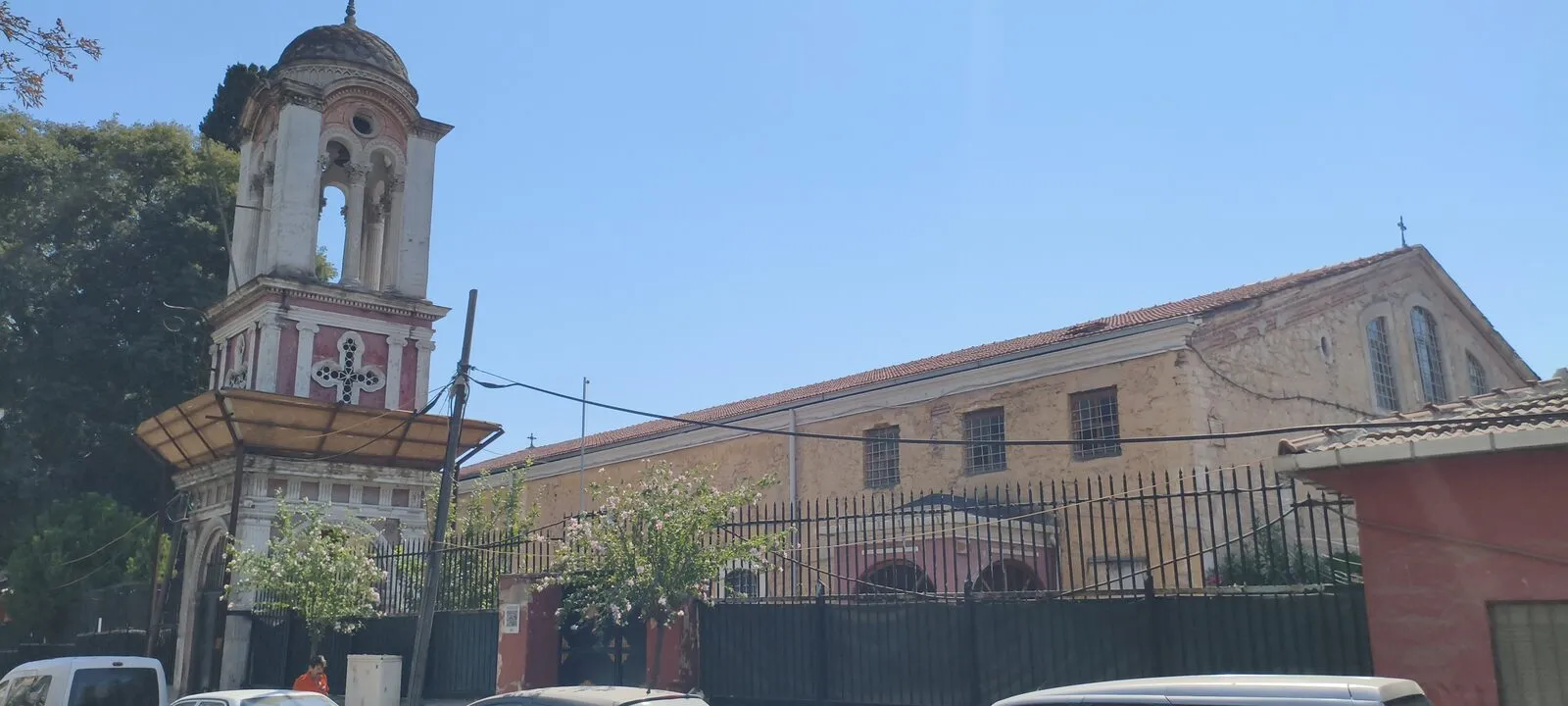 Ο ναός των Αγίων Κωνσταντίνου και Ελένης με το ψηλό ελεύθερο καμπαναριό, από τον δρόμο