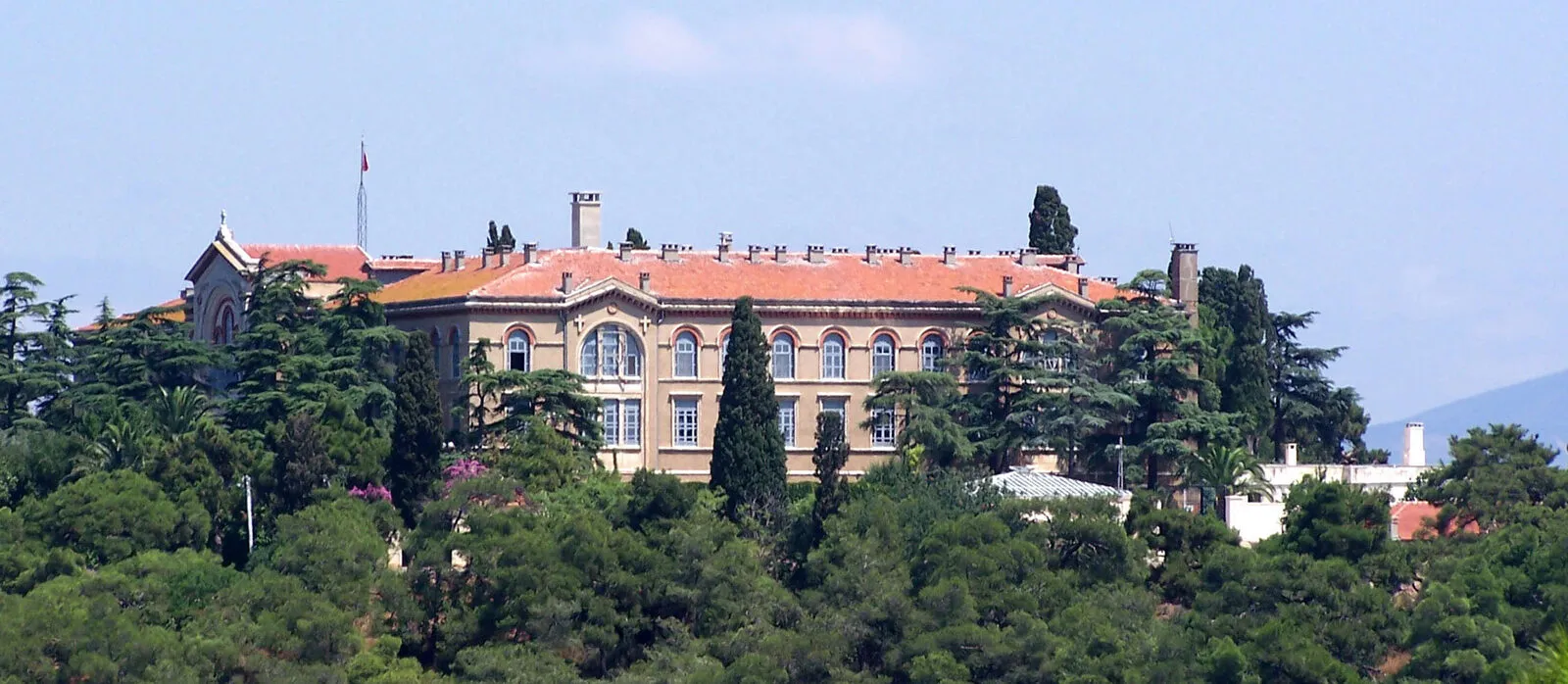 Το συγκρότημα της μονής και της Θεολογικής Σχολής ανάμεσα στα πεύκα, στην κορυφή του λόφου