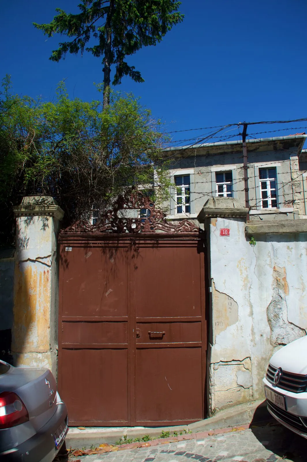 Η πύλη του σχολείου προς τον δρόμο, με τον επάνω όροφο του κτιρίου πίσω από τον τοίχο