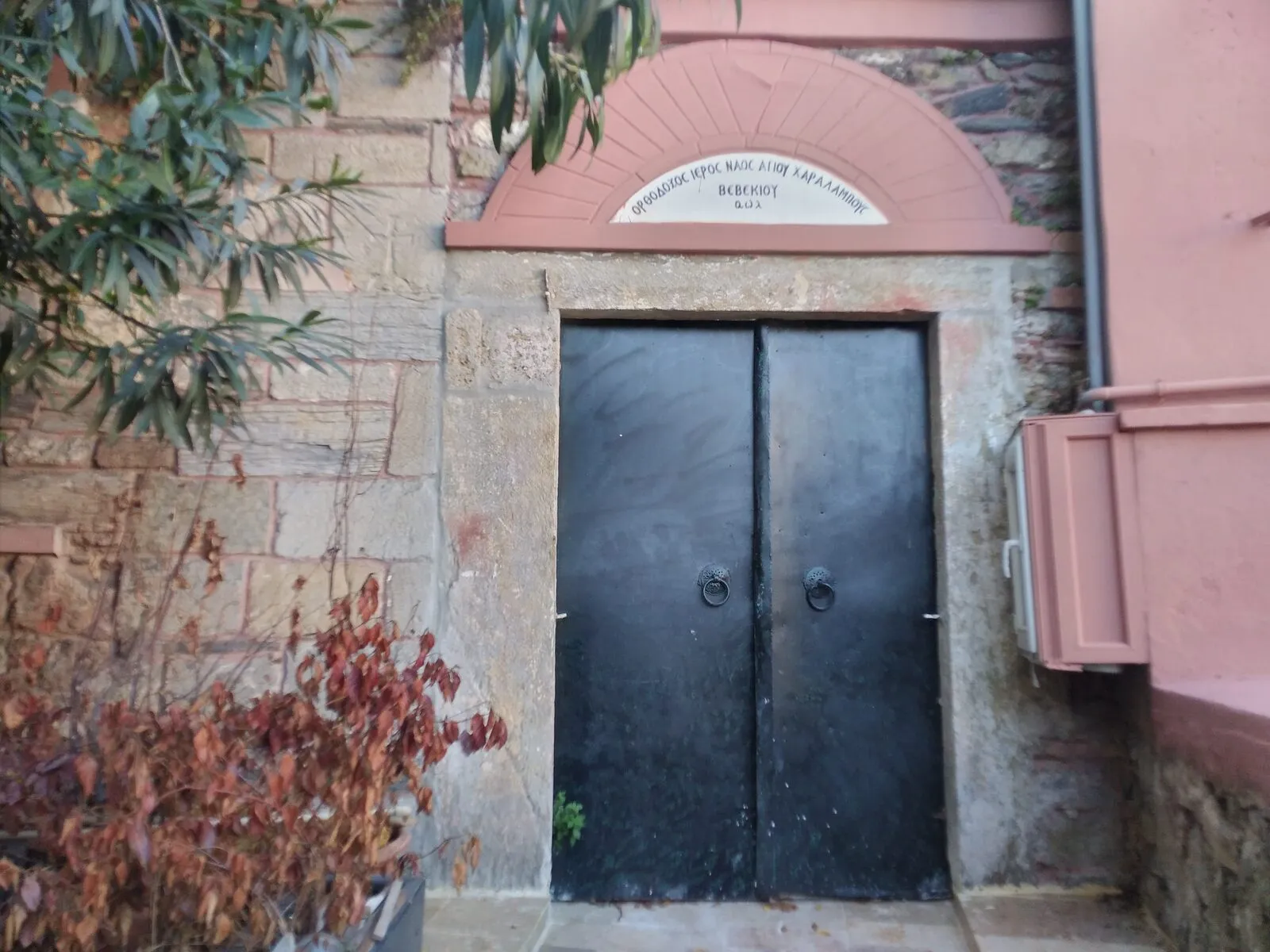 Η θύρα του ναού με την ελληνική επιγραφή του ονόματός του από πάνω