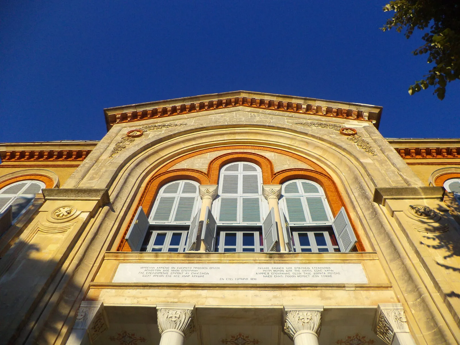 Η κεντρική πρόσοψη της σχολής με την είσοδο, τοξωτά παράθυρα και επιγραφή