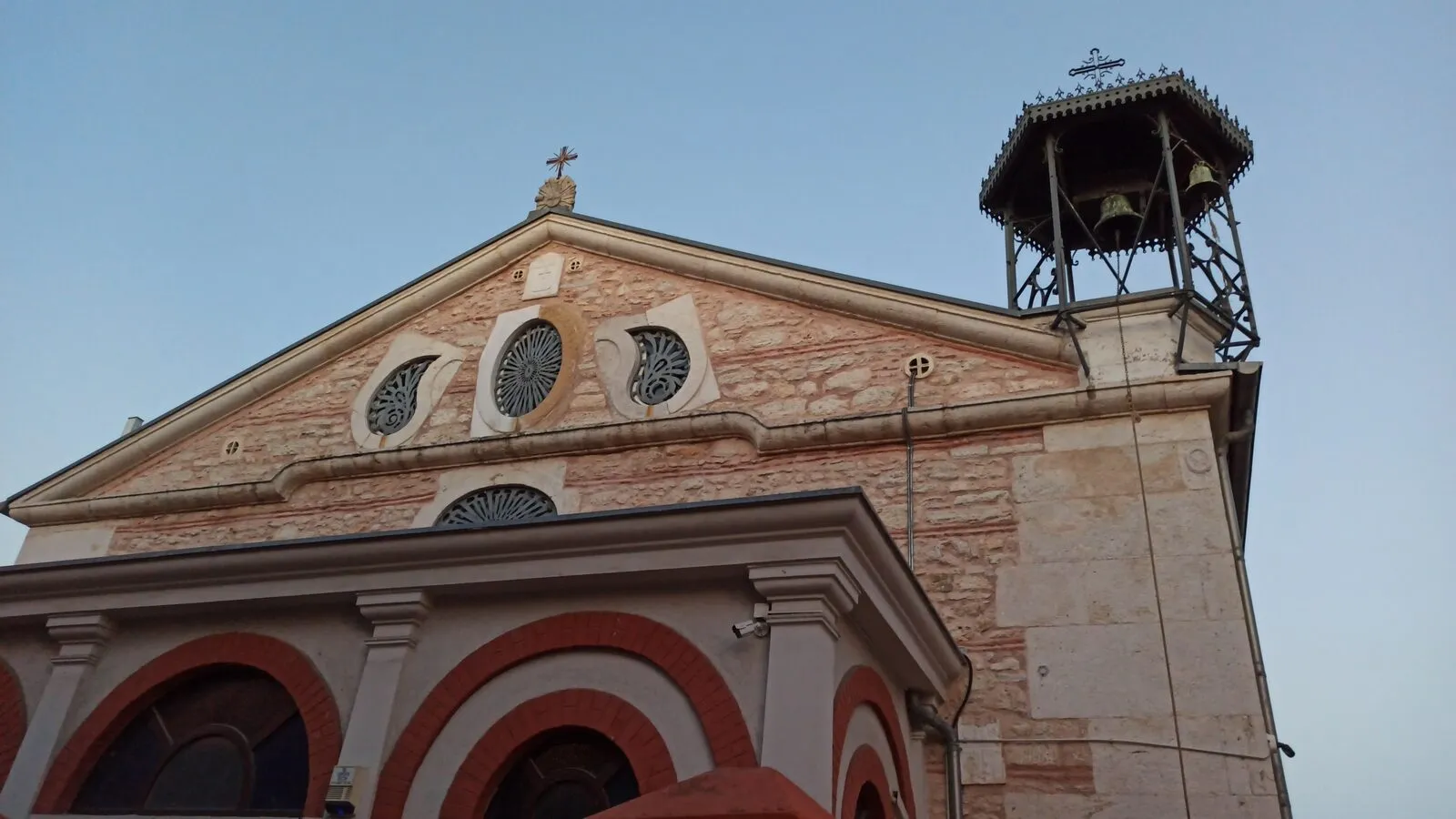 Το αέτωμα με τα στρογγυλά παράθυρα και το μικρό σιδερένιο καμπαναριό